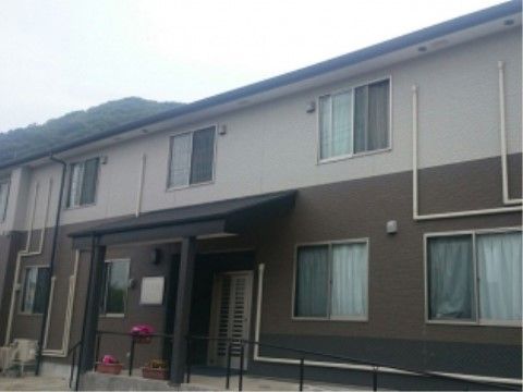周辺は自然豊かな住宅街である。施設の屋外でも、車椅子をご利用の方がスムーズに移動が行えるように、玄関につながるスロープを設置している。