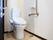 洗浄付き便座が設置されたトイレには、手すりが備え付けられている。また緊急時の呼び出しボタンも用意されている。