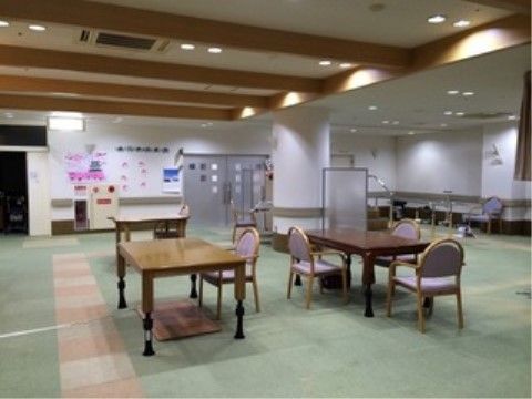 天井が高く、木製の梁が渡された黄緑色の絨毯敷きの広間