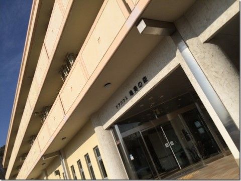 ガラス窓の自動扉の入口が中央にある３階建ての建物の外観