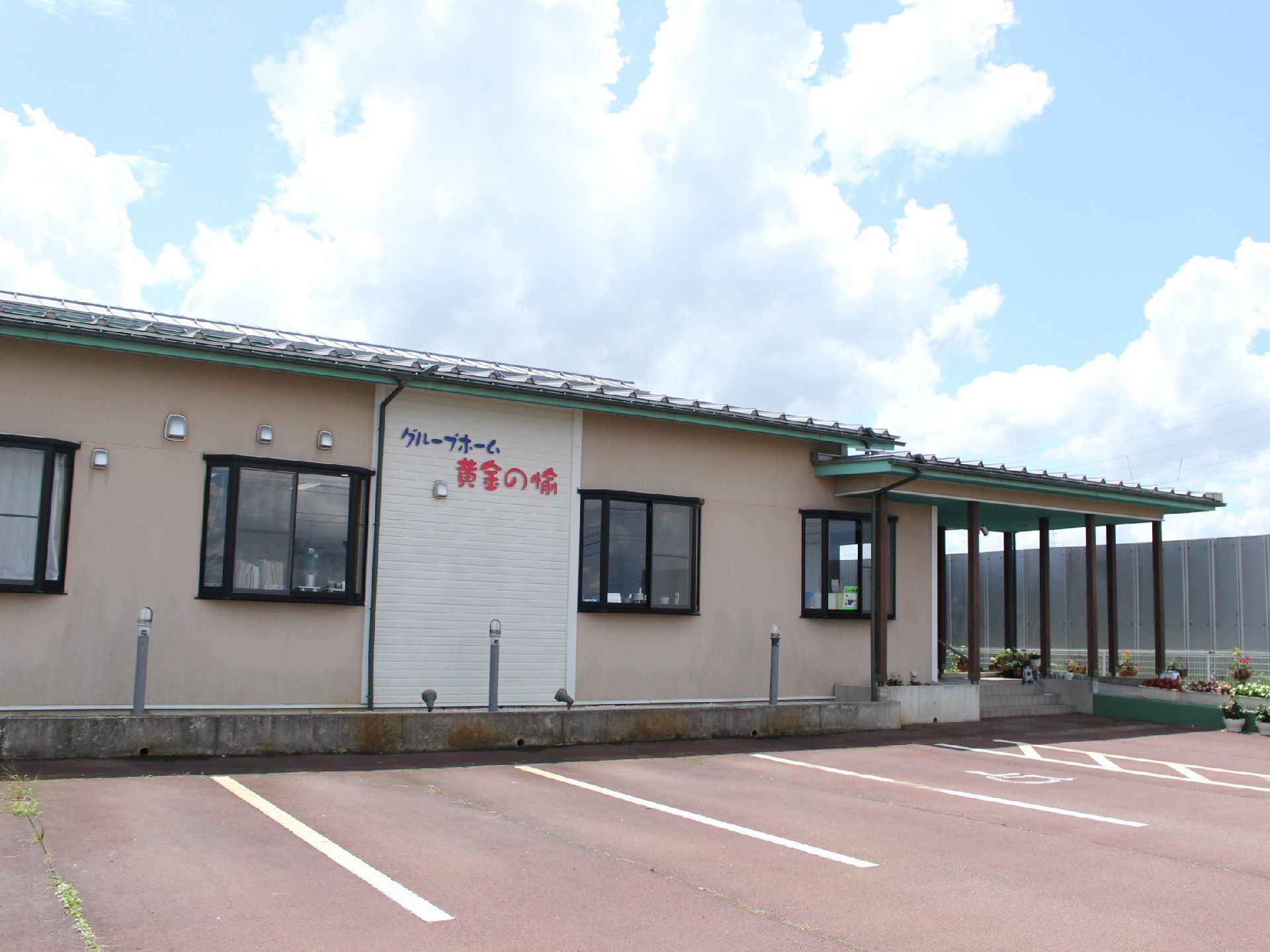 壁に赤い字と青い字で施設名が表示されている平屋建ての建物