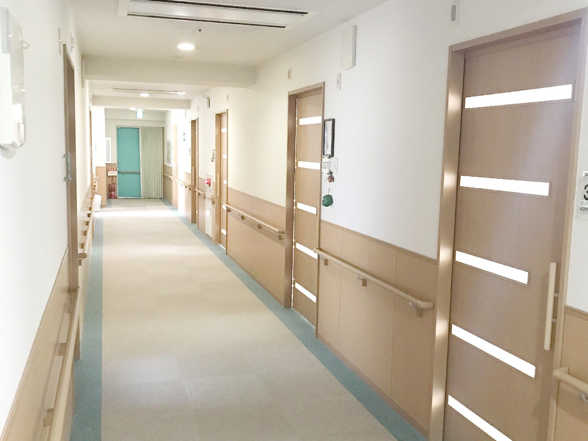 廊下は両方の壁に手すりが付いている。火災報知器や消火器が設置してある。縦長の取っ手が付いたドアがあり、それぞれに表札が出ている。