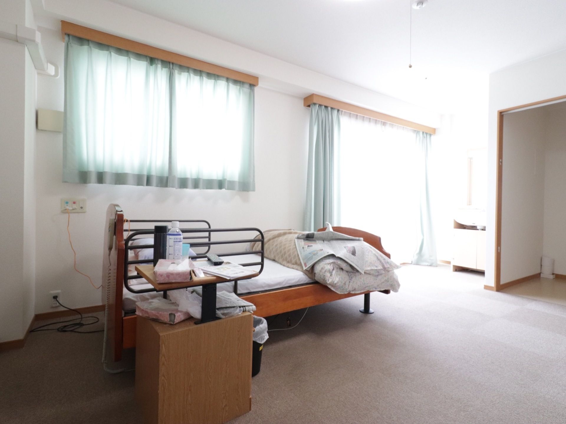 広さを備えた居室には、左右に転落防止用の柵が付いたベッドが置かれている。脇には飲み物や本を置くことのできるコンパクトなサイドボードがある。