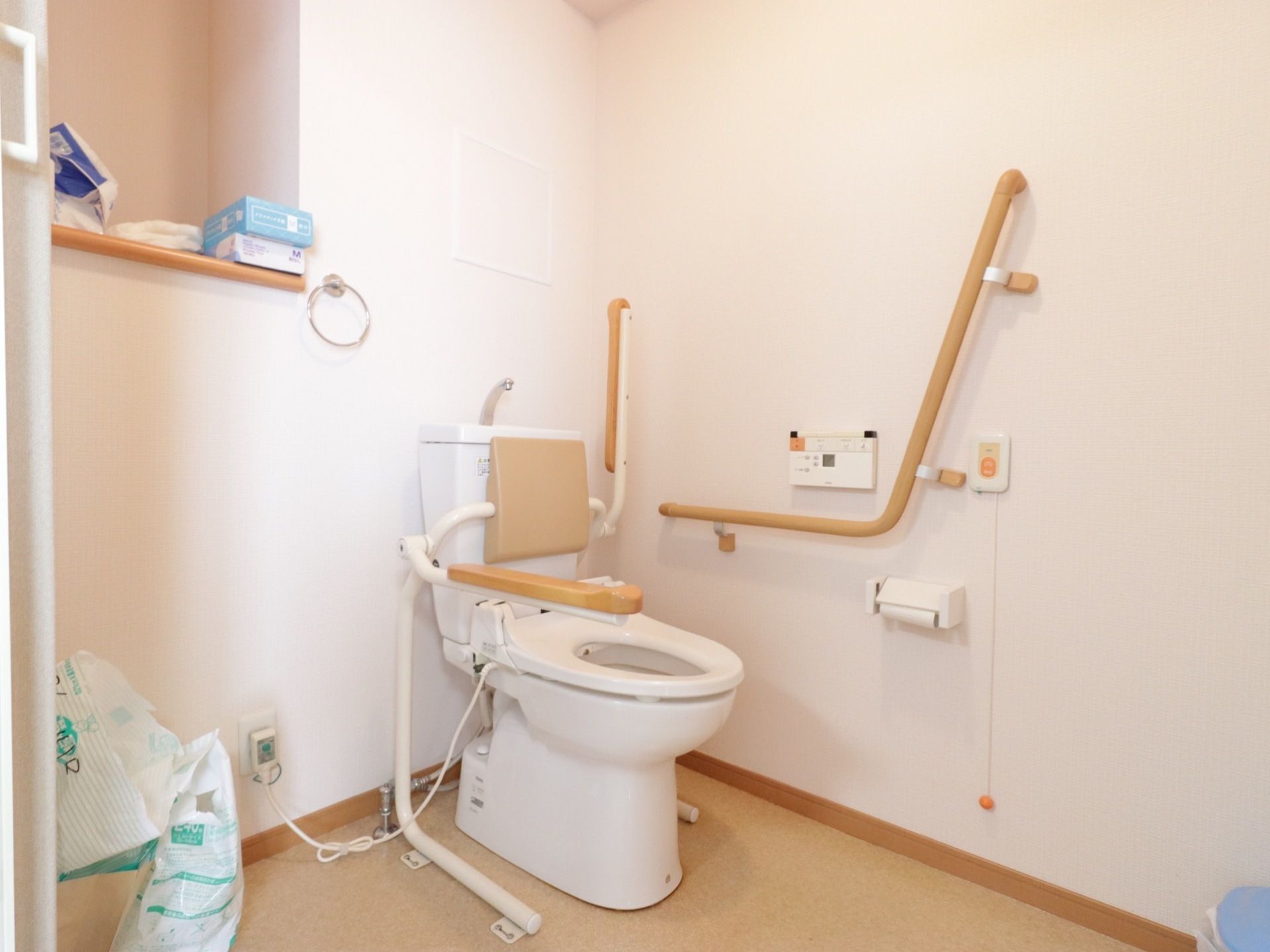 トイレには温水洗浄便座が備わっているので、衛生的で寒い冬でも冷えることがない。壁の上方には用具を置ける棚が付いている。
