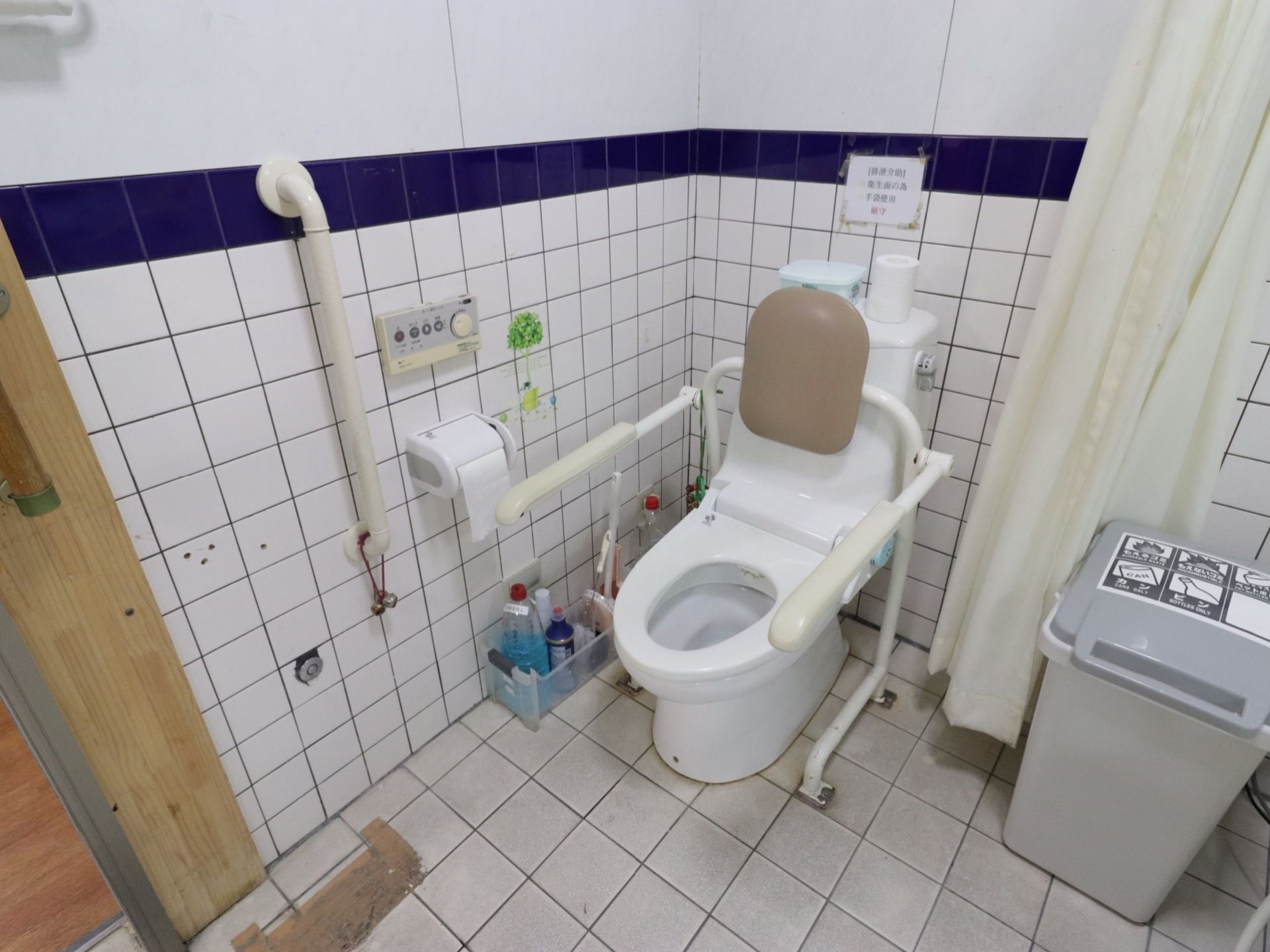 温水洗浄便座が設置されたトイレである。操作ボタンが壁に取り付けられており操作が簡単である。カーテンで仕切られており、出入りしやすい。