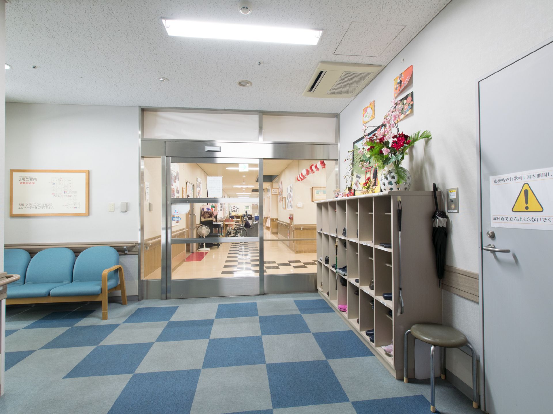 大きな靴箱が設置されている。靴を履き替える時は、いすに座って靴べらを使えば安全にできる。ベンチも設置されている。