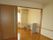 広いフローリングの部屋は、引き戸で二部屋に仕切ることができる。奥の部屋には白の棚が２つ置かれている。エアコンも完備されている。