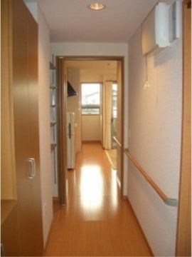 長い廊下がある。壁際には手すりをつけている。窓際に部屋があり、仕切りはアコーディオンカーテンになっている。
