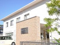 明るく清潔感のある建物。敷地内に緑を植え、入居者様の生活環境を整えている。二階建てで親しみやすい雰囲気がある。