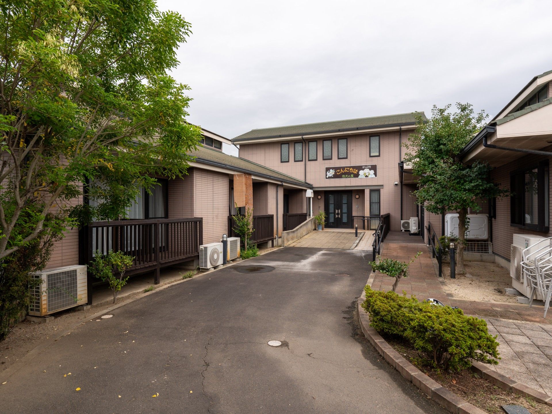 薬を飲む高齢女性に水を差し出す女性スタッフ