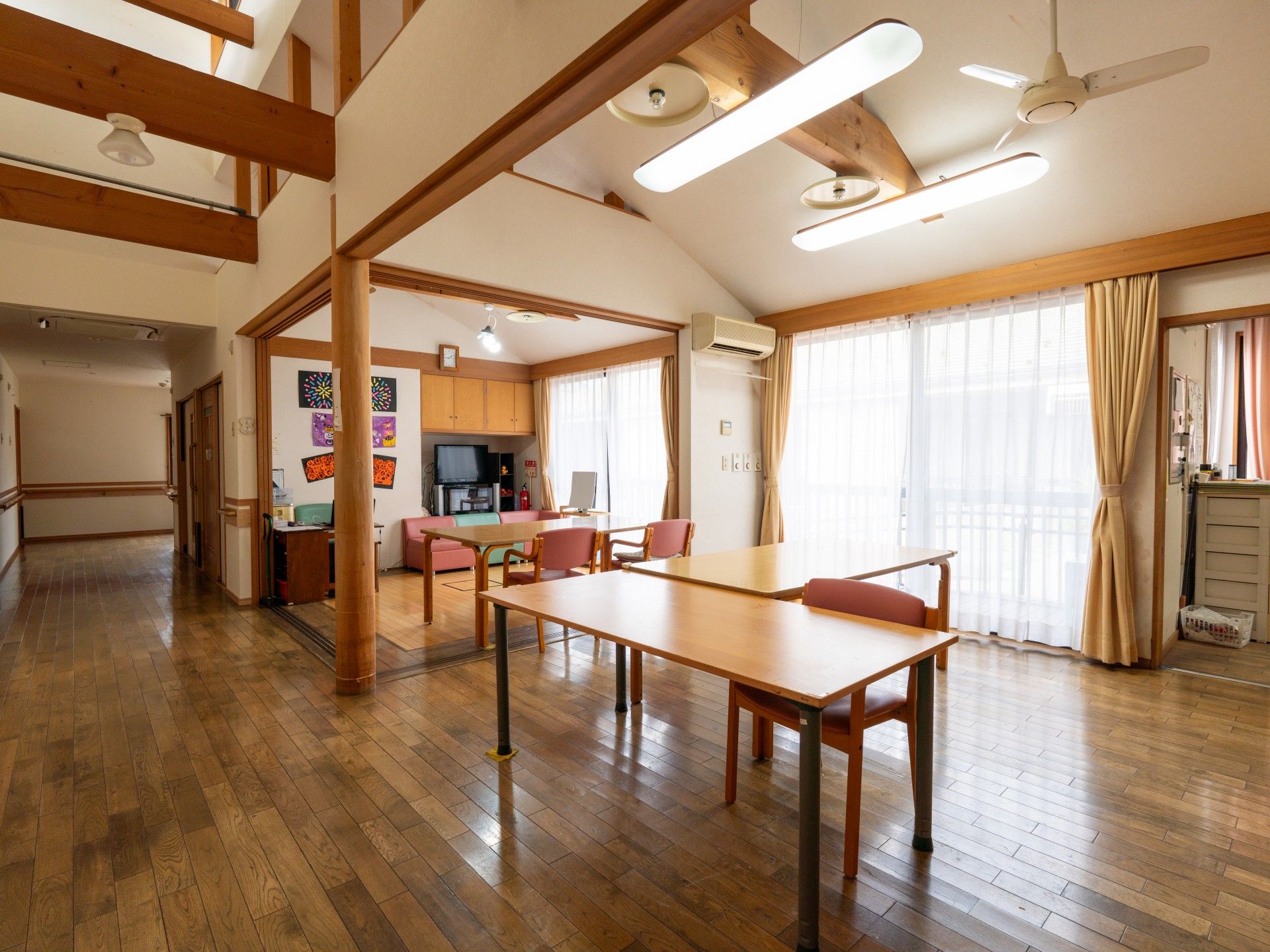 車椅子に座っている笑顔の高齢女性と手を差し伸べる女性ヘルパー