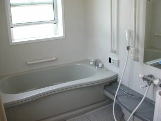 落ち着いたグレーの浴室で、自宅のように過ごせる。開口部が広いタイプの窓が設置され、気持ちよく換気もおこなえる。
