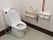 白を基調とした清潔感のあるトイレである。壁には、手すりや緊急ボタンはもちろん、可動式のひじ掛けもついている。