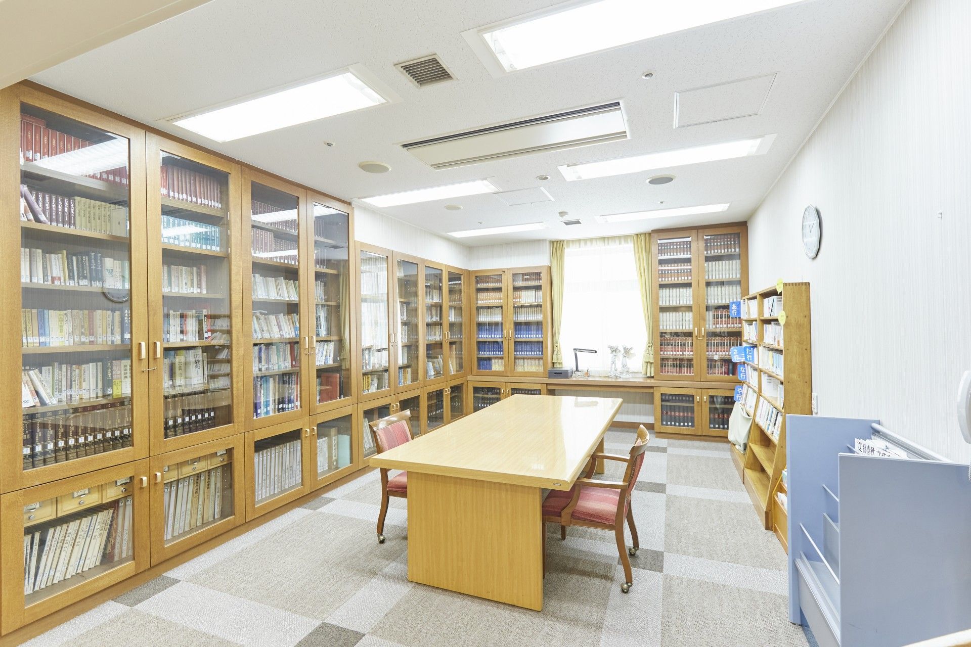 図書コーナーには、たくさんの書籍が収納された本棚が設置されている。部屋の中央には、テーブルと椅子が用意されている。