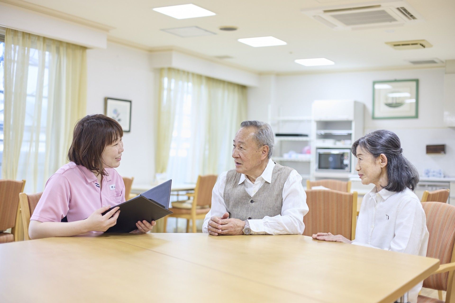 笑顔のスタッフ3人立つ居室