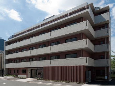 コンクリートと木材を使用した5階建ての施設で、各居室にベランダがある。入り口付近には、駐車スペースがある。