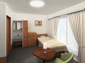 モダンな内装の居室には、収納棚が充実している。窓が大きいので、自然光を取り入れやすい。ベッド近くには、洗面台とトイレがある。