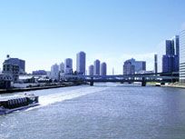 施設の近くにあるゆったりと流れる大きな川と、その向こうには橋と街並みがうかがえる。川のほとりを散歩してリフレッシュしていただける。