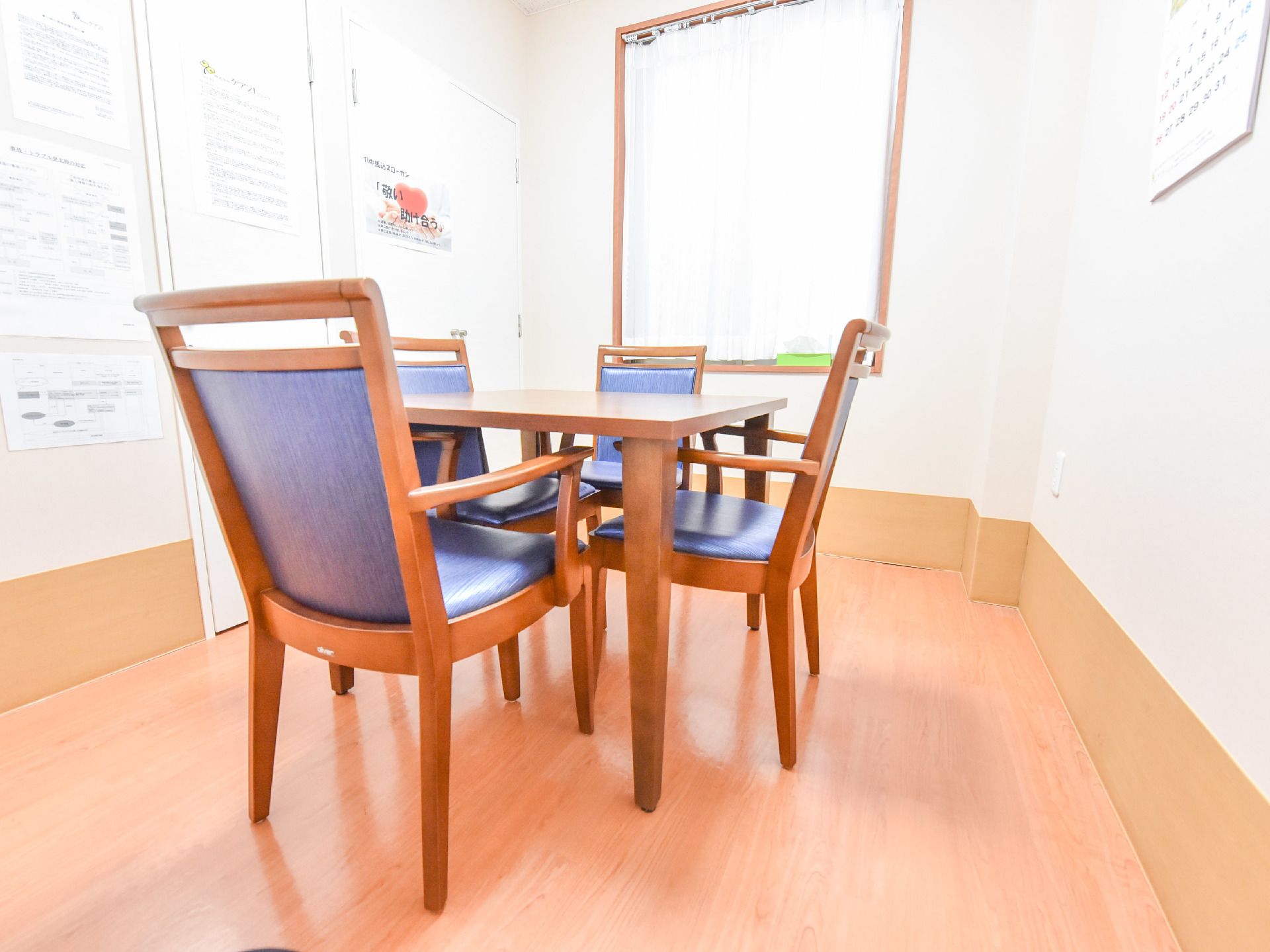 大きな窓の付いた明るい個室。4人掛けのテーブルがある。