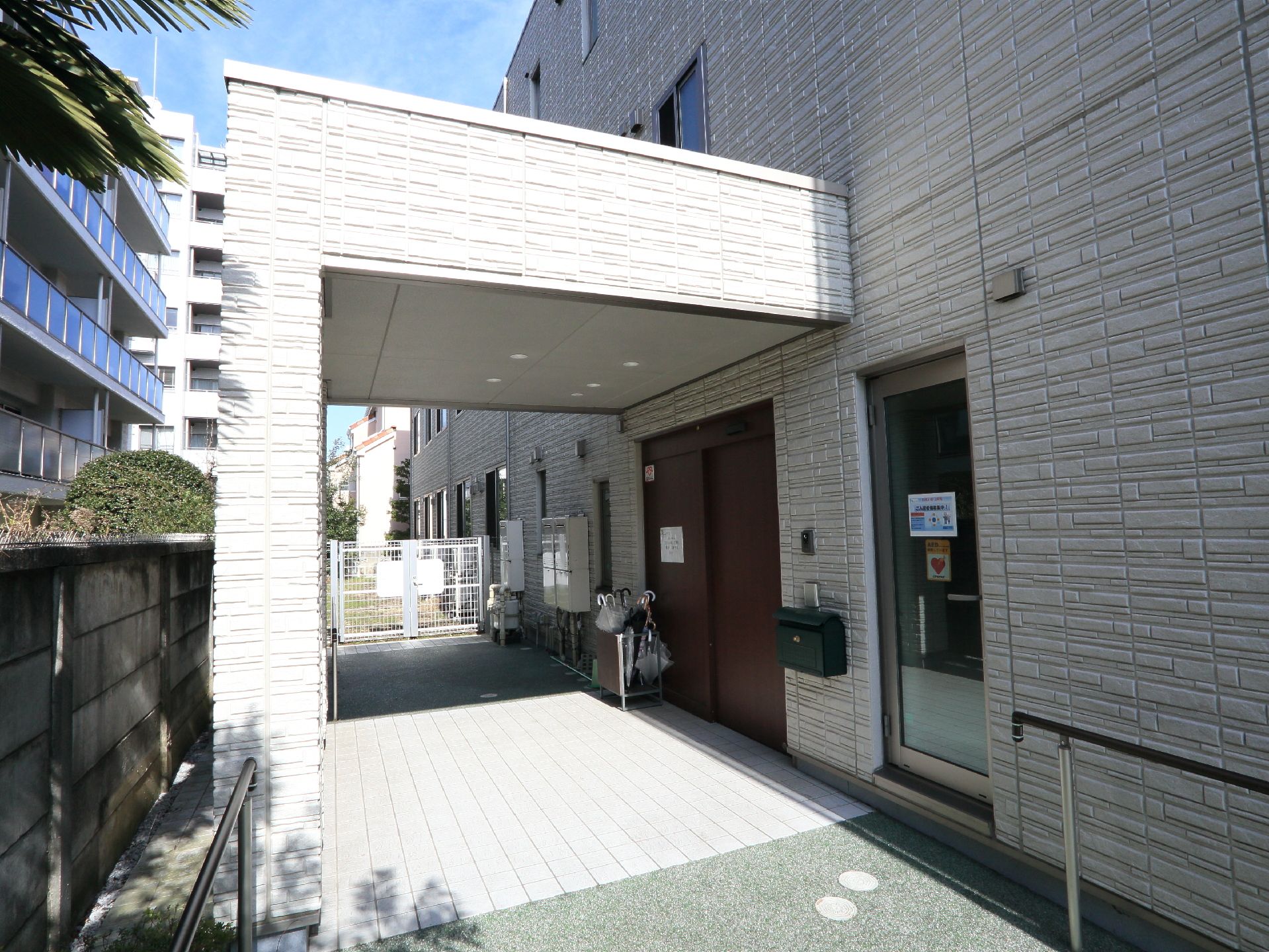 大きい扉で車いすの方でも出入りがしやすい。屋根もあり、玄関前で雨に濡れることがない。玄関前には左右に手すりがある。