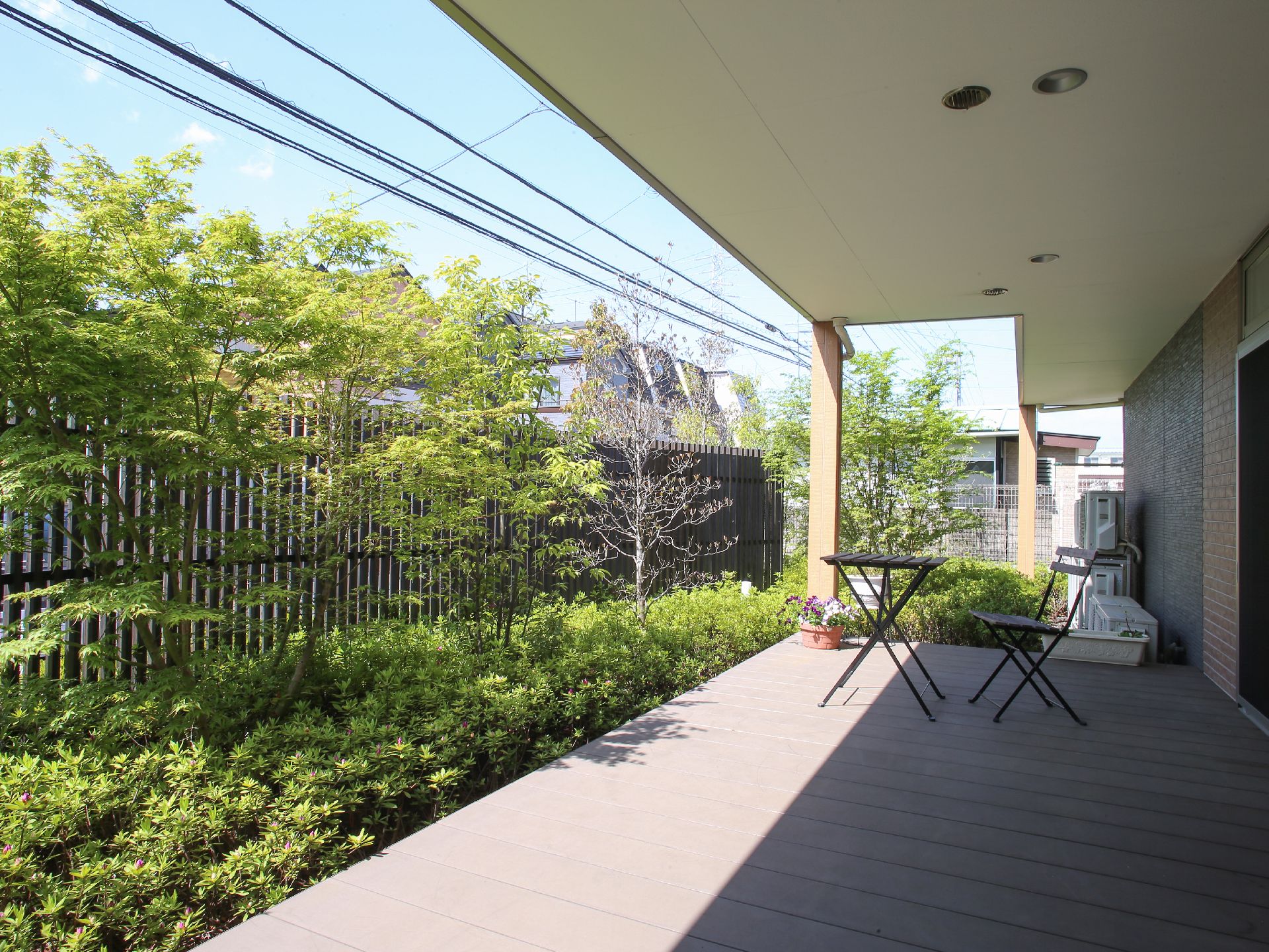 木や花など緑がある庭。そこに机や椅子があるため、外で陽の光を浴びながらゆっくりと過ごすことができる。