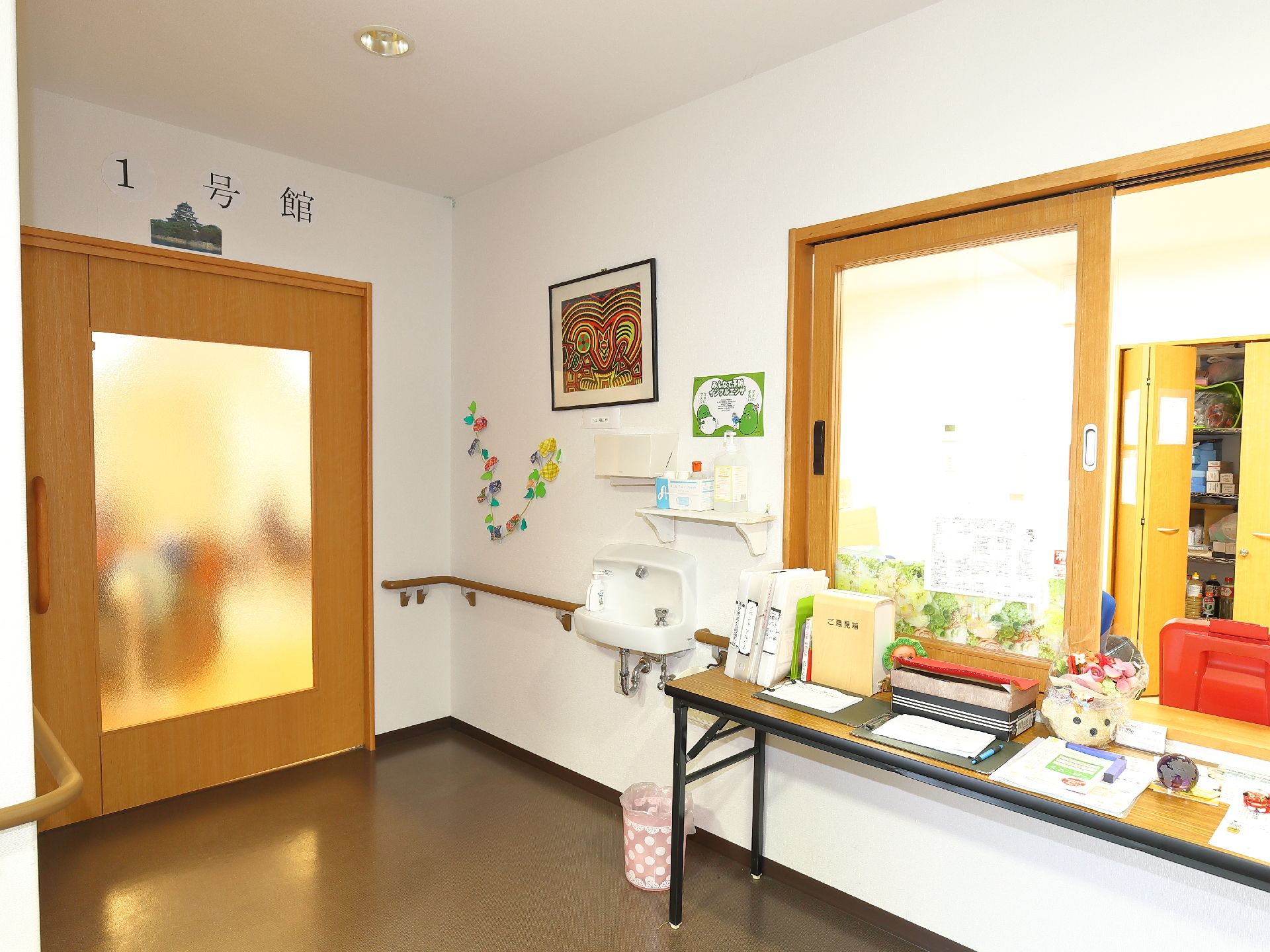 事務室前の壁には、絵が飾られていたり、花の飾りが飾られていたりしていて、華やかな雰囲気となっている。