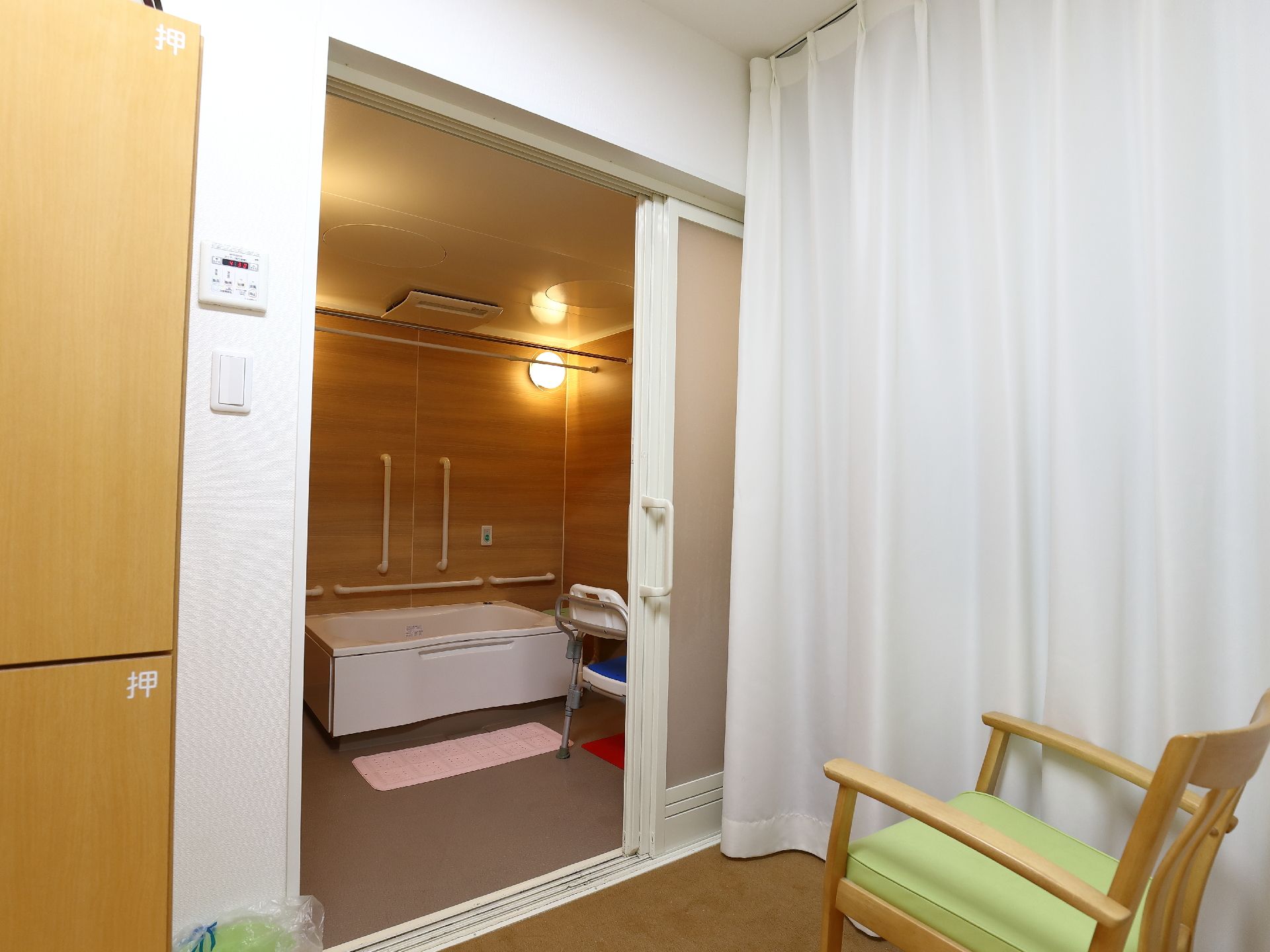 浴室のドアは利用がしやすいように引き戸になっている。また、入浴前後に休憩をしやすいように浴室前に椅子を完備している。