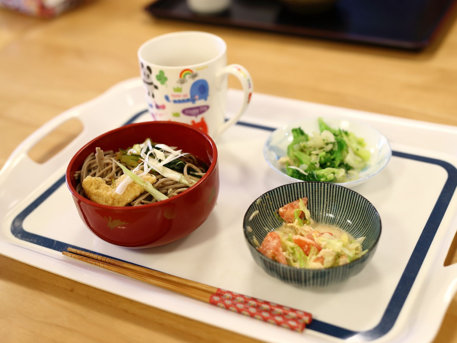 食事は入居者の方一人一人にお盆にのせて配膳される。この日のメニューは、きつねそばにサラダとおかず一品が栄養バランスよく提供されている。