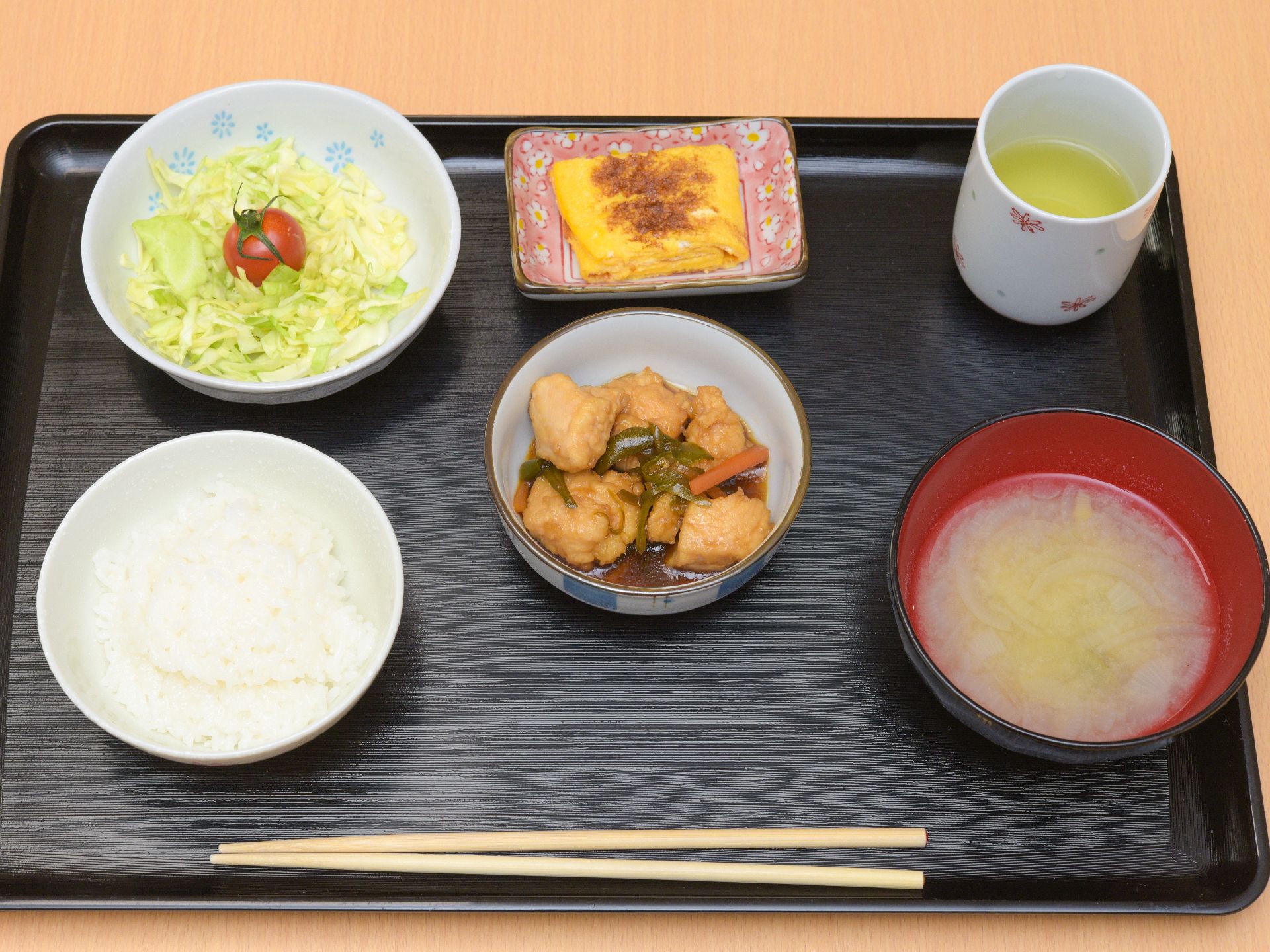 一汁三菜でバランスのとれた和食中心の食事とトレイに乗せて提供している。水分を補給できるようにお茶も提供している。