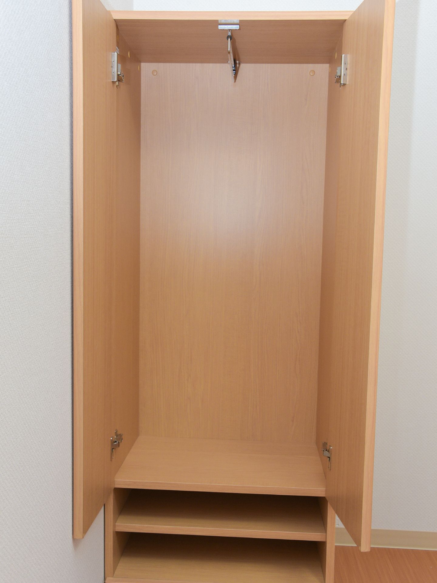 個人用のクローゼットを完備している。丈の長い服もかけることができるハンガーポールも備えている。下の棚には雑貨などを収納できる。