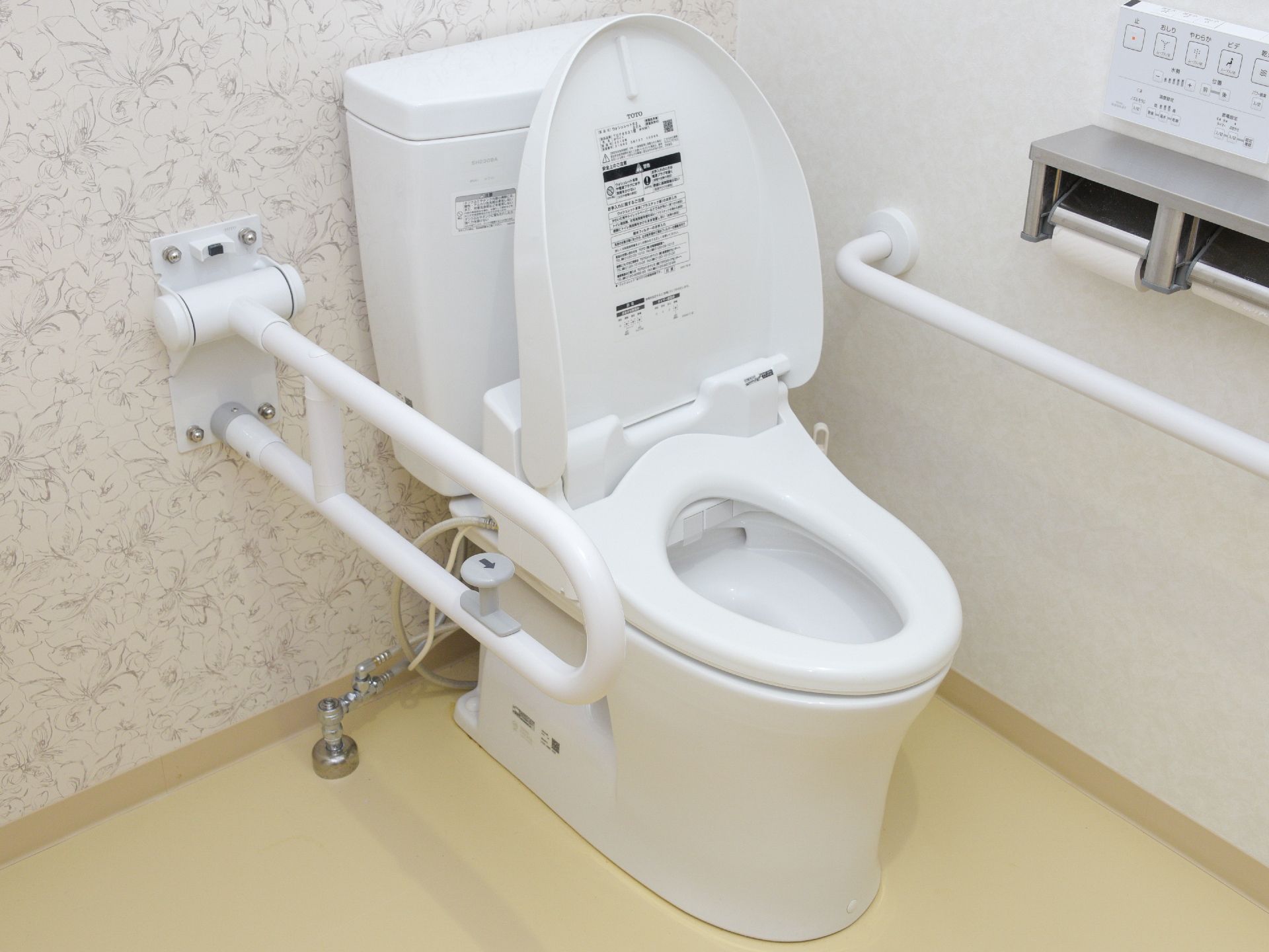 トイレの両側に手すりを設置している。片側の手すりは上に可動するタイプ。車いす利用者も安心して利用ができる。
