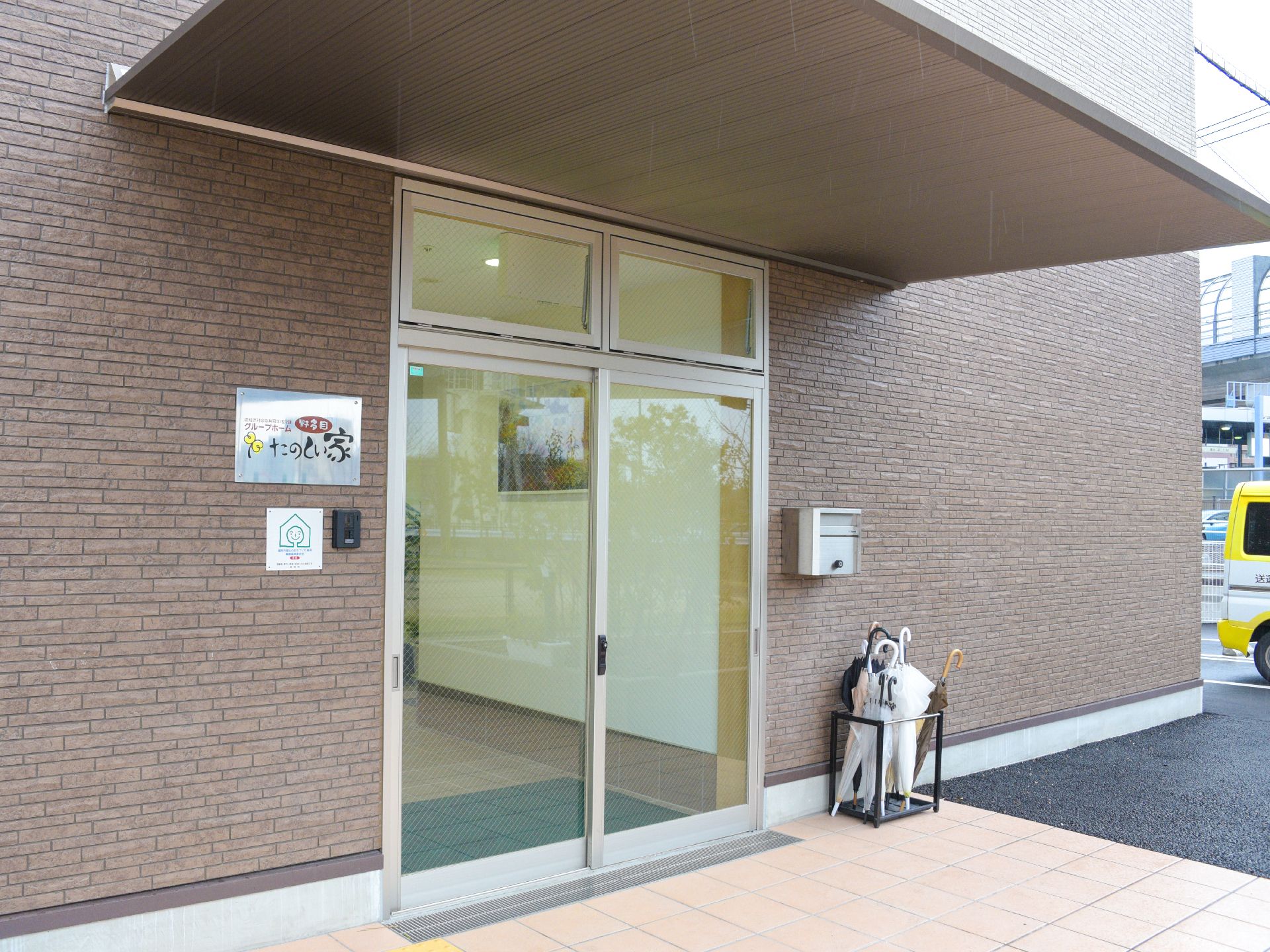 施設の玄関は、利用者が利用しやすい引き戸になっている。水滴で床が濡れないように傘たては外に設置している。