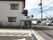 看板の様子である。道路に面した駐車場の入り口付近に、施設名や電話番号が書かれた看板が掲げられている。