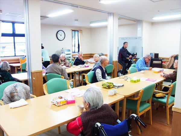 緑色の椅子が並んだテーブルセットで昼寝やお茶を楽しむ入居者様