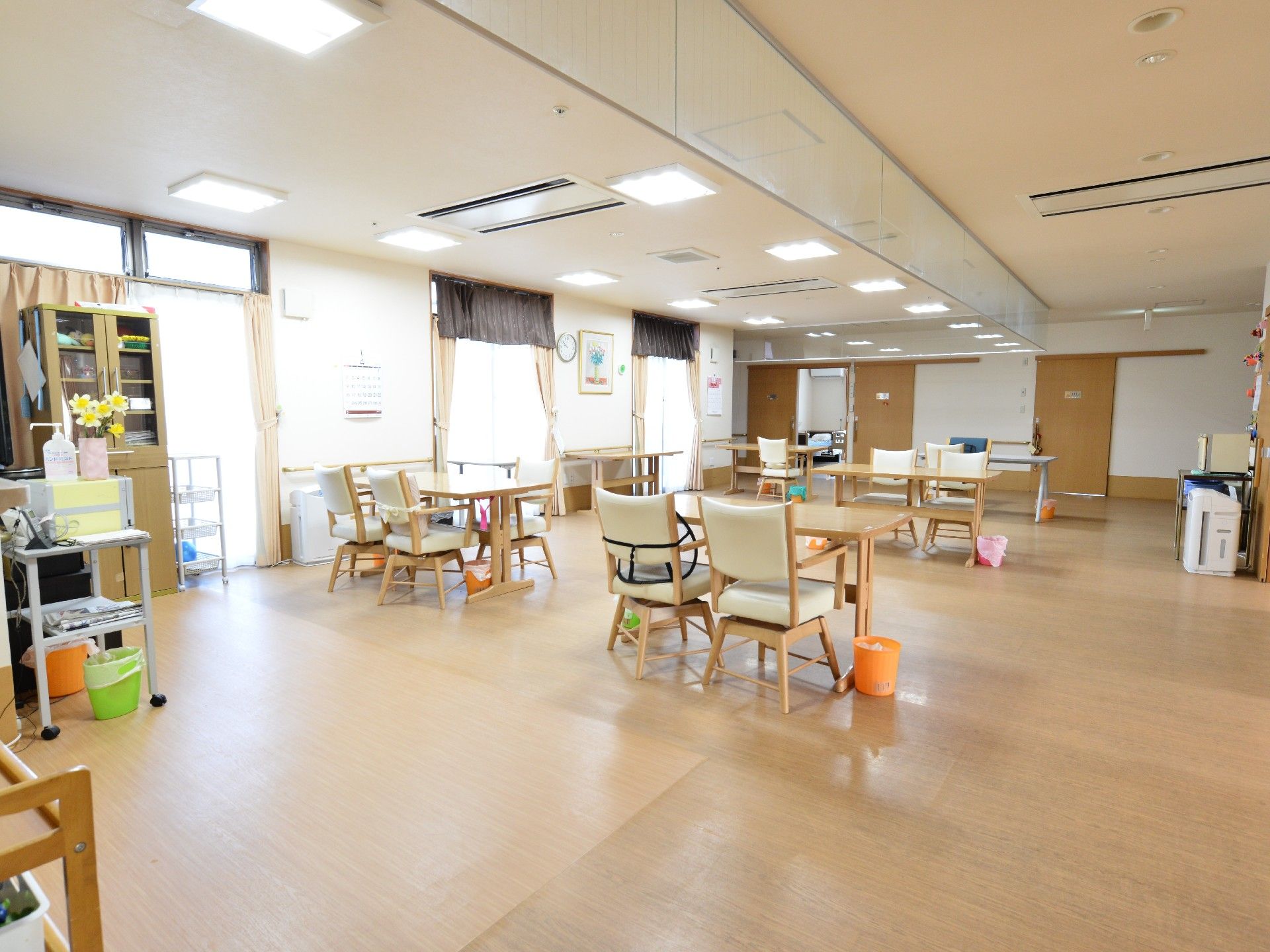 間隔をあけてテーブルが置かれている広いリビング。