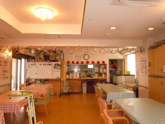 ダイニングテーブルが並べられた、大勢で食事ができるスペースである。奥には厨房があり、カウンターから配膳できる。