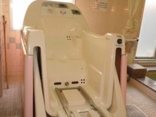 座ったまま入浴可能な介護入浴機器が置かれた浴室である。換気ができる窓があり、外の光を取り込むことができる。