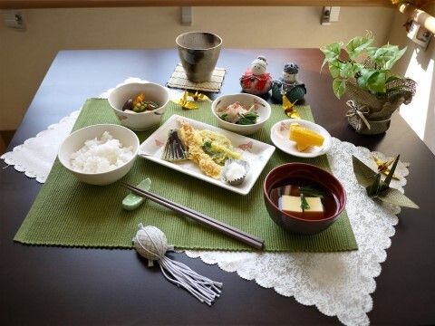 天ぷらを中心に数種類の小鉢が並ぶ、バランスの良い和食メニュー。ランチョンマットや季節の飾り物で華やかに飾られている。