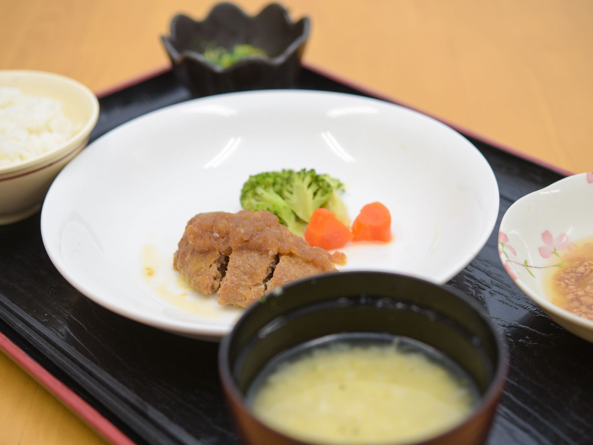 メインは、お肉料理。シンプルな白の器に人参のオレンジ色とブロッコリーの緑色が料理を鮮やかに見せている。