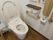 トイレの壁には木製の手すりが備え付けられている。呼び出しボタンや水洗ボタンもある。水洗ボタンには流すと書かれたシールが貼られている。