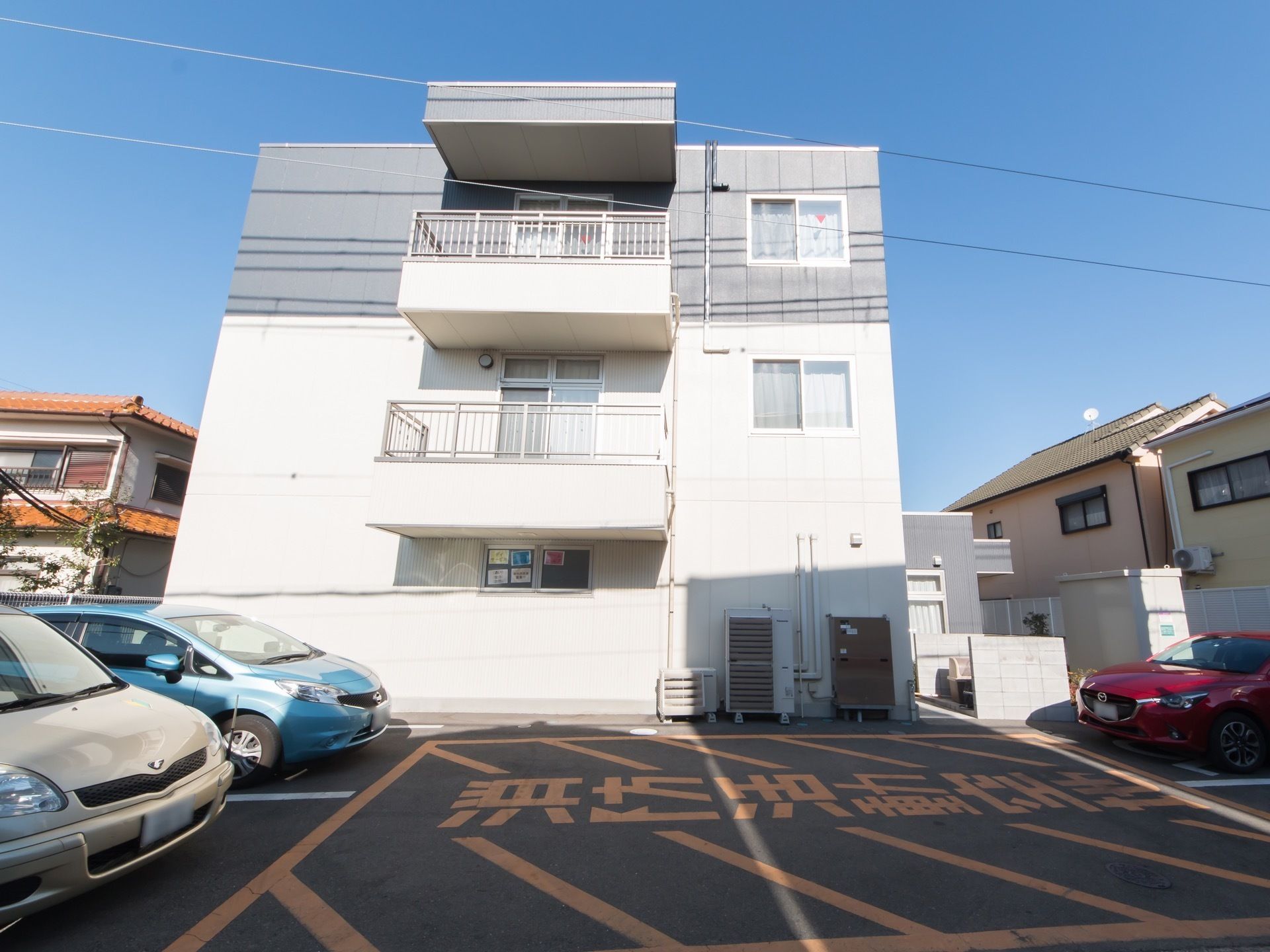 施設は3階建で1階と2階は白色、3階はグレー色の外観である。ベランダや窓もある。敷地内には駐車場が完備されている。