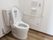 温水洗浄便座が採用されたトイレになっており、操作ボタンが壁に取り付けられている。呼出しボタンが設置されている。