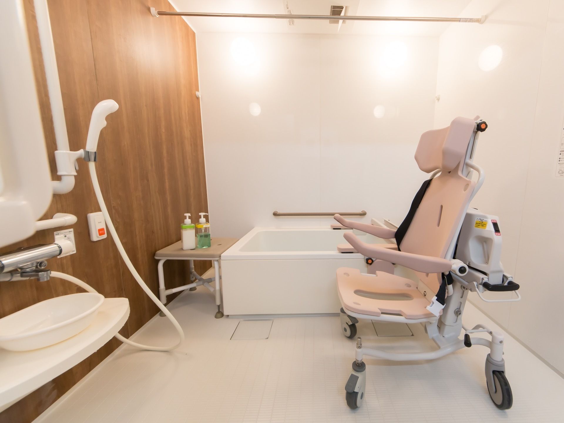 白を基調とした清潔感のある浴室である。浴室専用の車椅子やシャワー、非常用呼び出しブザーが完備されている。