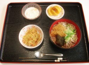 薬味ののった麺と、デザートのカットフルーツなどがセットになった食事