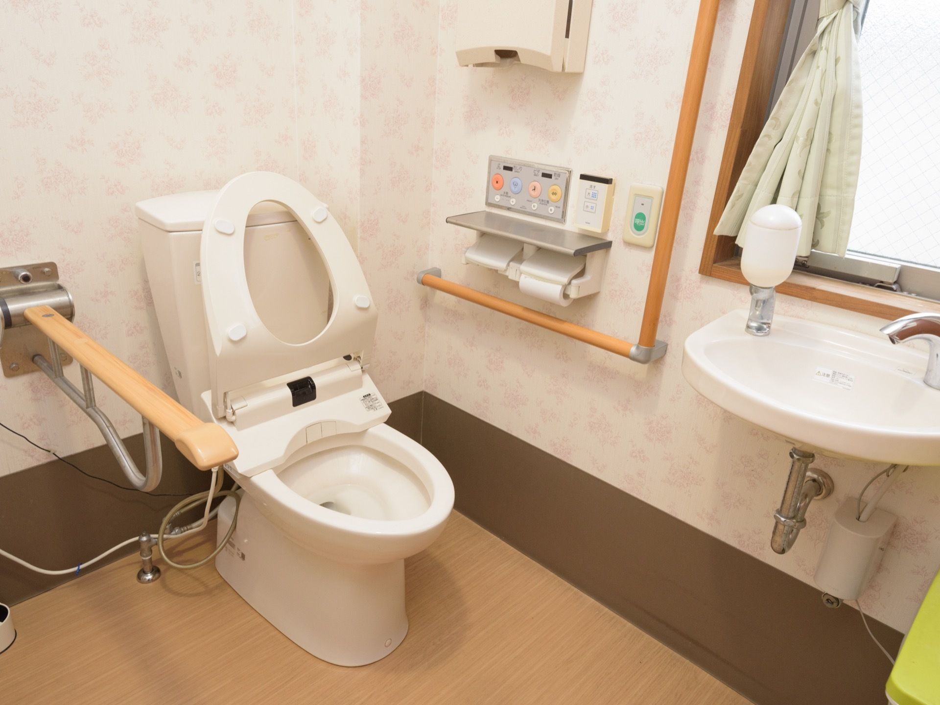 洗面台とペーパータオルがある。トイレは温水洗浄便座になっており、洗浄ボタンがある。ゆとりのある空間になっている。