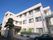 住宅街の中にある３階建ての施設。２階と３階の間の壁に施設名が大きく書かれている。施設の前には車が２台ほど駐車できるスペースがある。