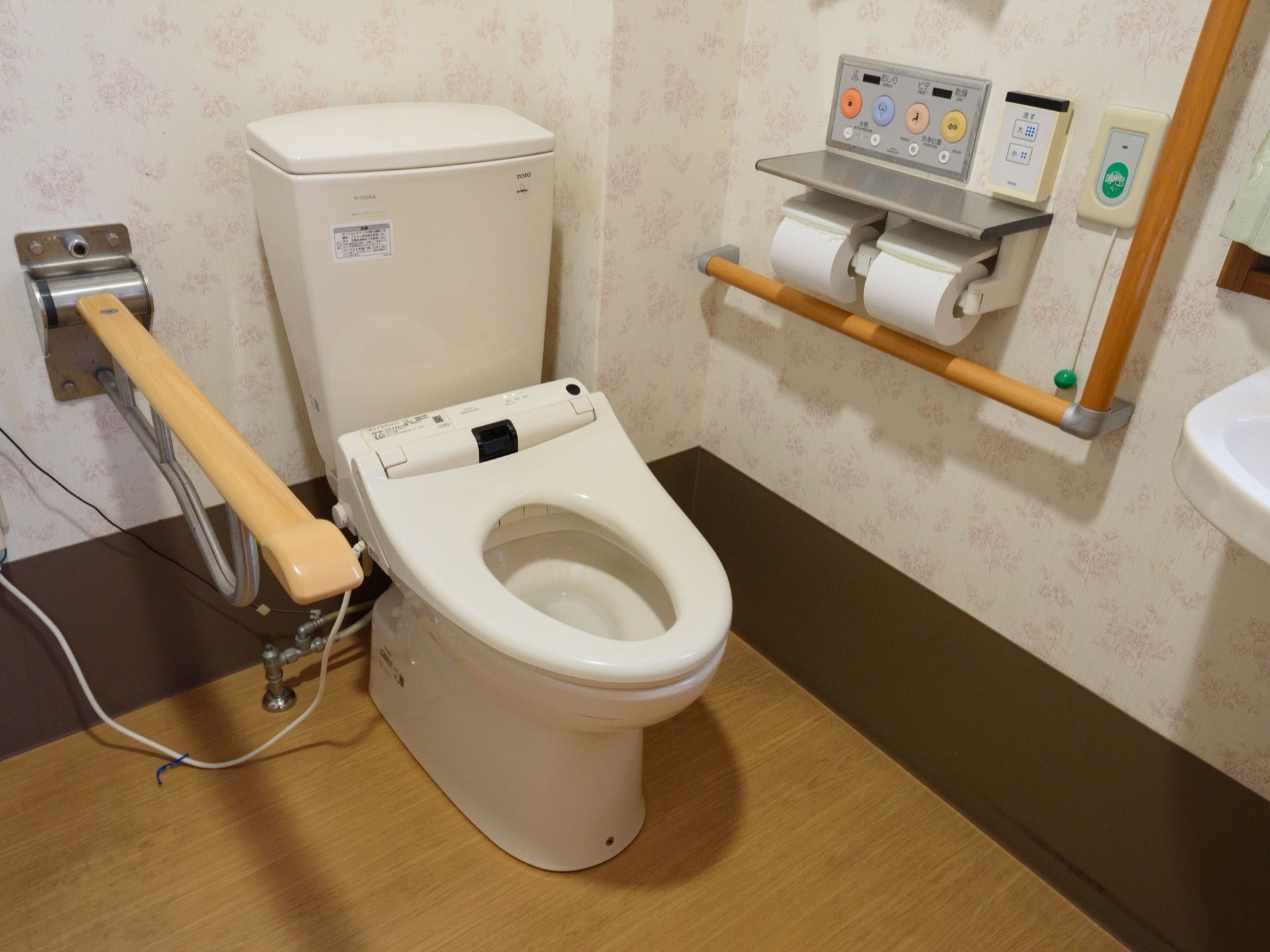 便器に座って右側にある手すりは可動式で、使用しない時は跳ね上げることができる。洗浄機能などのボタンが大きく使いやすい。