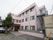 施設は、３階建ての建物で外階段がついている。玄関にはポーチが設置されている。玄関の扉はダークブラウンの格子模様である。