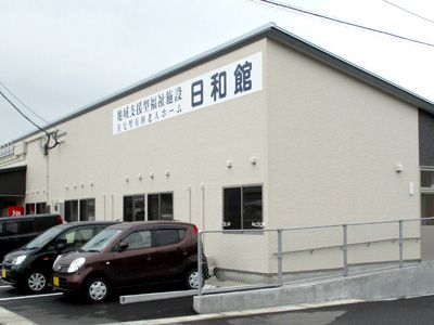 閑静な住宅街に佇む２階建ての施設である。白を基調とした外観で、目に留まりやすいように建物上の外壁に施設名の看板を掲げている。