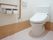 白い壁とベージュの床が清潔感のあるトイレである。サイドも広々としたスペースがあり、ストレスなく利用することができる。